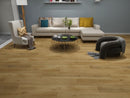 Modern living room with wooden flooring, gray sofa, and decorative items.