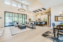 Modern living room with gray sofa, coffee table, and large windows. Carlo