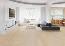 Modern living room with a gray sofa, coffee table, and large windows. Cactus