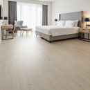 Modern bedroom with a bed, chairs, and decor.