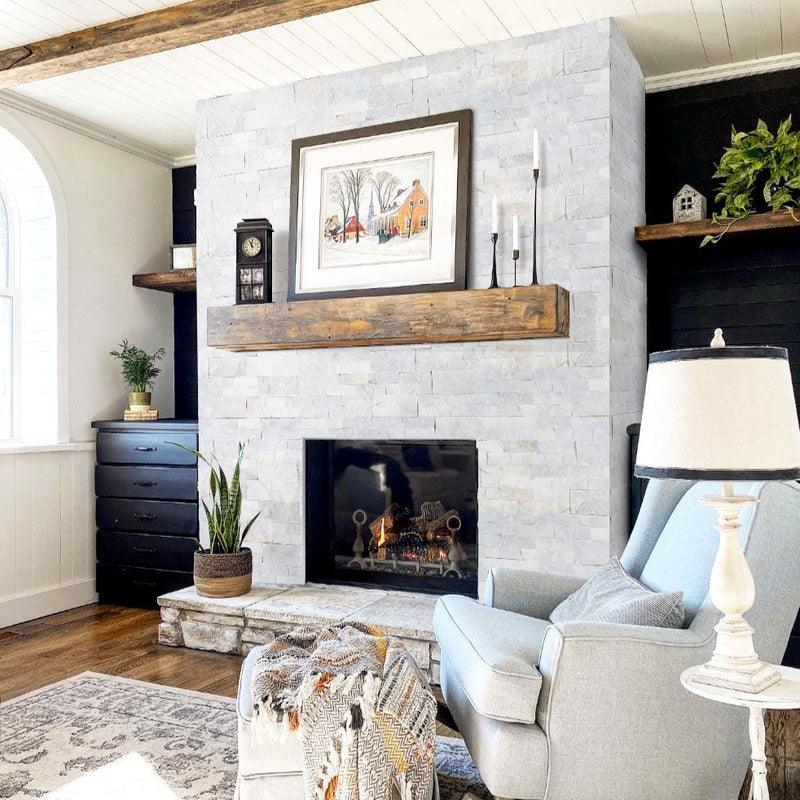Carrara White Ledger 3D Panel 6"x24" Natural Marble Wall Tile - Full Truckload installed indoors around fireplace wooden mantel candles gray armchair and ottoman wooden floors