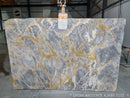 Marble slab with gray and gold patterns in a warehouse setting