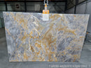 Marble slab with gray and gold patterns in a warehouse setting