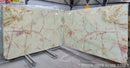 Green onyx slabs with red veining on a gray floor.