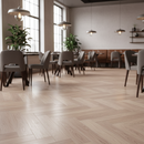 Modern dining room with wooden flooring, tables, and chairs.