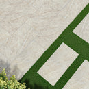 Beige stone tiles with a green grass strip and plants on the side