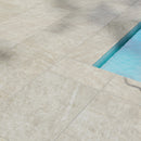 Close-up of beige tiles with a pool edge in the corner