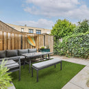 Outdoor patio area with gray furniture on a grassy patch, wooden fence, and trees. LTRFPEME6X8-38MM81OZ