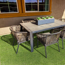 Outdoor patio set with a table and chairs on a grassy area. LTRFPEME7.5X10-28MM56OZ