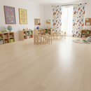 Children's playroom with wooden floor, bookshelves, and colorful curtains.