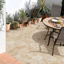 Light Antique Travertine Pattern Tumbled Pavers - Full Truckload installed patio with lots of planters and plants with iron wrought table nd chairs orange juice on it