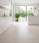 Modern kitchen with white cabinets, a plant, and a view of greenery outside.