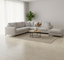Modern living room with a gray sectional sofa, coffee table, and decorative items.