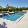Rectangular pool with lounge area and outdoor furniture on a sunny day.