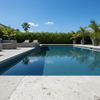 Pool area with lounge chairs, potted plants, and a clear blue sky.
