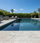 Pool area with lounge chairs and a clear blue sky