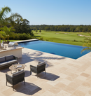 Outdoor patio with pool, chairs, and table overlooking a golf course