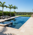 Modern pool area with lounge furniture and palm trees on a sunny day.