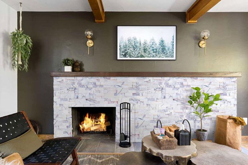 New York Ledger 3D Panel 6"x24" Natural Marble Wall Tile - Full Truckload installed around fireplace under wooden mantel shelf with wood decor and modern chair