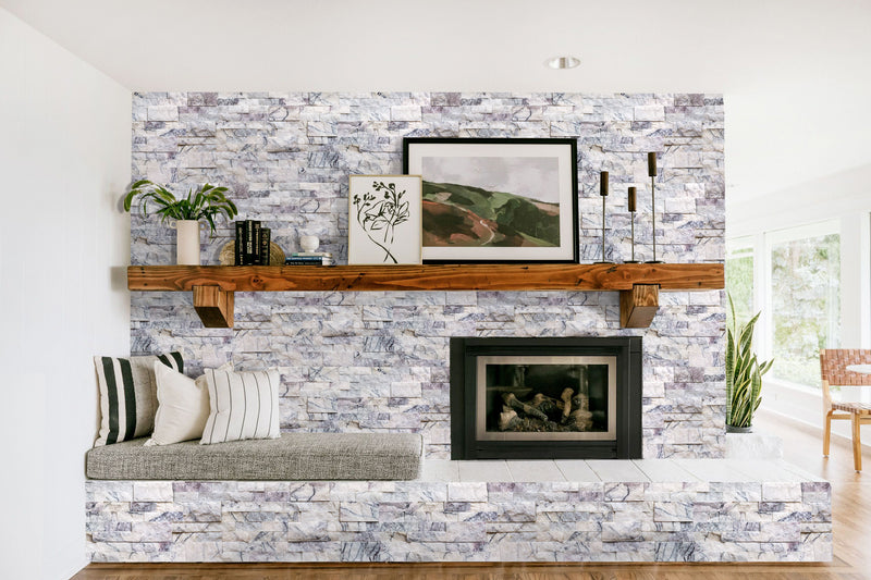 New York Ledger 3D Panel 6"x24" Natural Marble Wall Tile - Full Truckload installed around fireplace wooden mantel setting corder pillows and a scenery painting on the wall