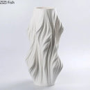 Sculpted white ceramic vase set with purple flowers for bedroom decor