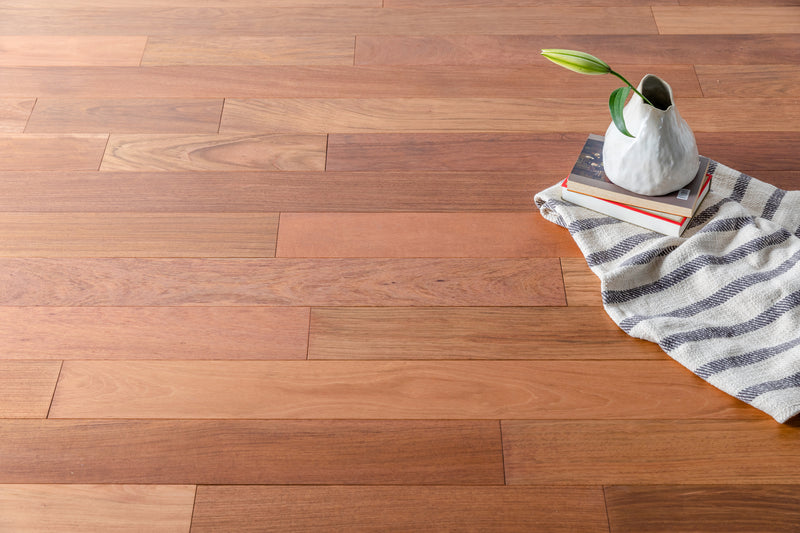 Solid Hardwood Prefinished Satin Mix Width, 84" RL, 3/4" Thick Smooth Brazilian Cherry Jatoba - Totem Collection books on floor closeup view