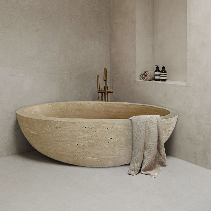 Troia Light Travertine Bathtub Hand-carved from Solid Marble Block (W)32" (L)70" (H)20" installed modern bathroom brown towel on the edge copper faucet