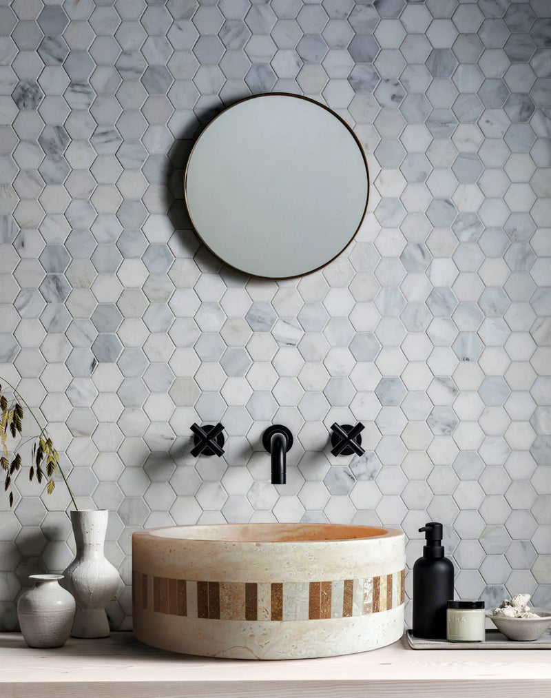 Troia Light Travertine Cylinder Above Vanity Bathroom Sink 2" Embedded Mosaics Border Honed (D)16" (H)6" bathroom view black wall-mounted 8" faucet round mirror and hexagon marble mosaic on the wall 