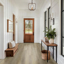 Foyer with wooden bench, plant, and door