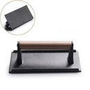 Black and light brown cast iron burger press kitchen meat tool