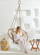 boves rast blue hanging round chair teak frame product shot wooden side table woman holding orange juice