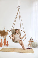 boves rast blue hanging round chair teak frame woman sitting orange vases wooden side table throw blanket leather slippers