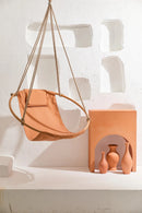 bresse rast blue hanging round chair teak frame woman sitting orange vases decorative angle shot