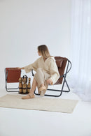 brown foldable metal frame faux leather chair black metal frame product shot woman sitting on