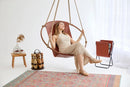 brown genuine leather hanging round chair teak frame blonde woman sitting magazine holder 