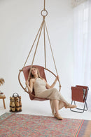 brown genuine leather hanging round chair teak frame blonde woman sitting magazine holder