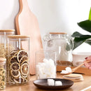 Clear glass storage jars with bamboo lids for kitchen organization