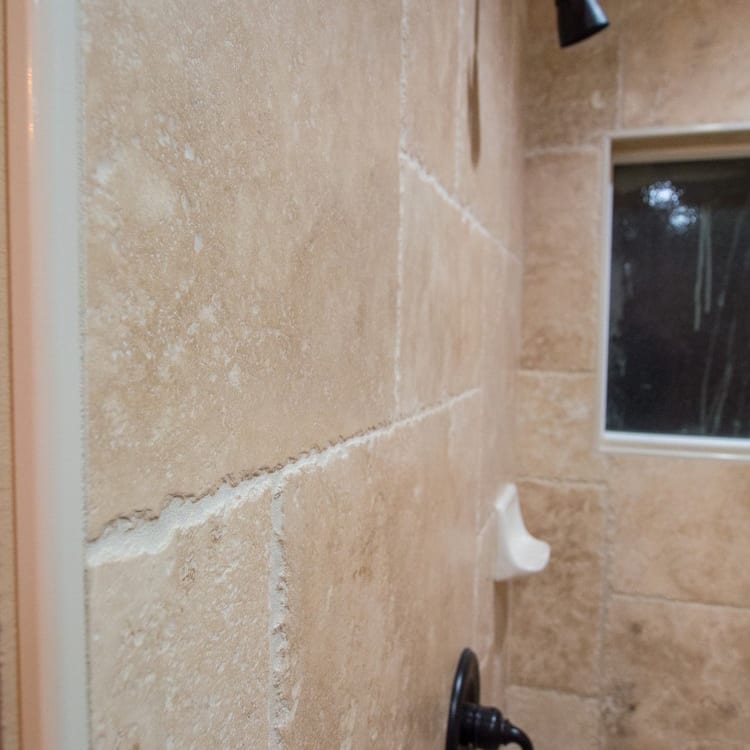 Denizli Beige Antique Pattern Travertine Tile - Full Truckload brushed and chiseled installed bathroom wall closeup view