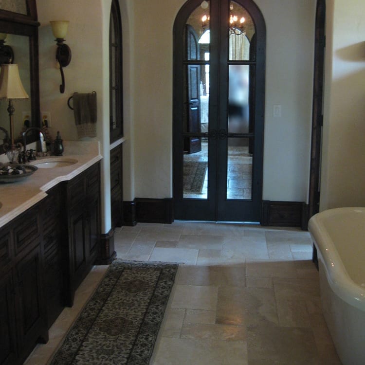 Denizli Beige Antique Pattern Travertine Tile - Full Truckload brushed and chiseled installed on bathroom floor with bathtub and marble counter and wooden vanity