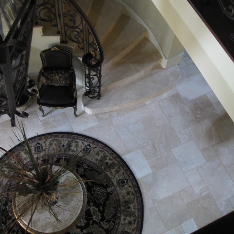 Denizli Beige Antique Pattern Travertine Tile - Full Truckload brushed chiseled installed on foyer with travertine stairs and round handwoven rug in brown tones