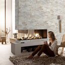 Diana Royal Ledger 3D Panel 6"x24" Honed Natural Marble Wall Tile - Full Truckload installed indoors wall 2 sided fireplace a blonde woman sitting on floor shag rugs holding a cup of coffee
