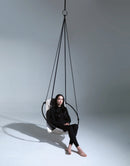 faux leather hanging round chair pearl product shot black dressed woman sitting