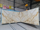 Large marble slab with gold veining in a warehouse setting