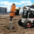 Skid steer loader with a concrete removal attachment on a construction site.