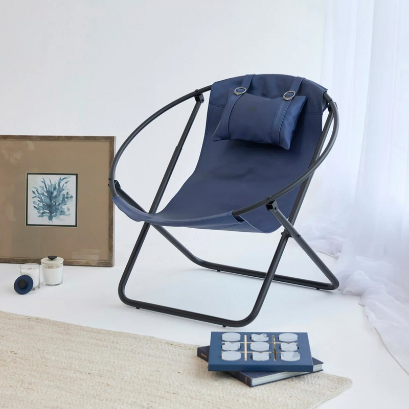 indigo foldable metal frame faux leather chair black metal frame product shot decorative items around