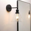Industrial black wrought iron wall lamp with clear glass shade bedroom