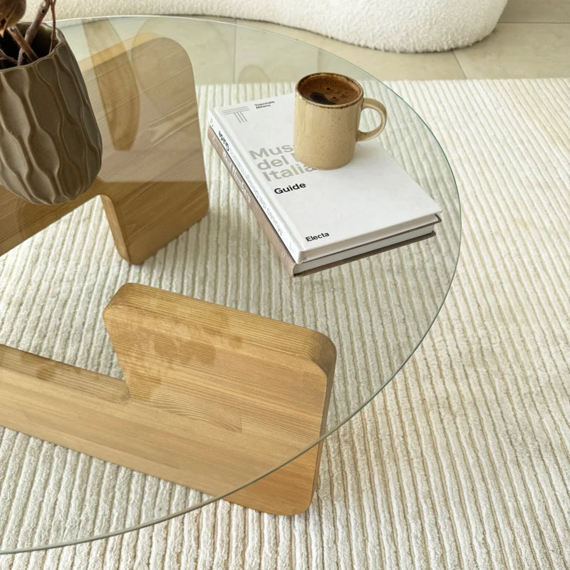 Mia Designer Coffee Table Solid Wood Oak Tempered Glass top (D)29.5" (H)13.75" living room books coffee mug candle on top white couch on the back closeup