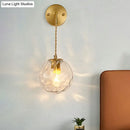 Minimalist gold ball sconce with hammered glass shade bedroom light