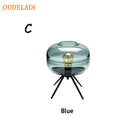 Modern amber glass table lamp with black tripod base for bedroom decor