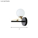 Modern black and brass wall sconce with white glass ball shade bedroom